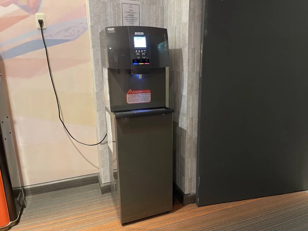 可以直接到電梯旁的飲水機取用熱水，距離不遠。