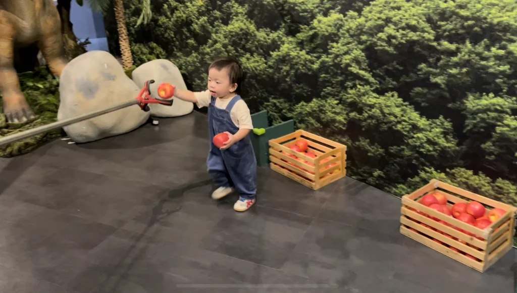 爸爸拿著長夾，弟弟負責一直把蘋果拿給爸爸。