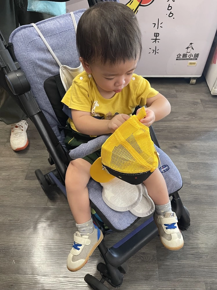 弟弟自己選了一頂黃色恐龍棒球帽，看他戴上帽子很開心，忍不住買給他。